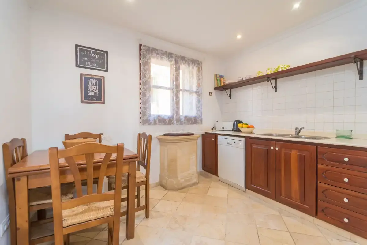 A kitchen and dining area with wooden seating beside the counter.