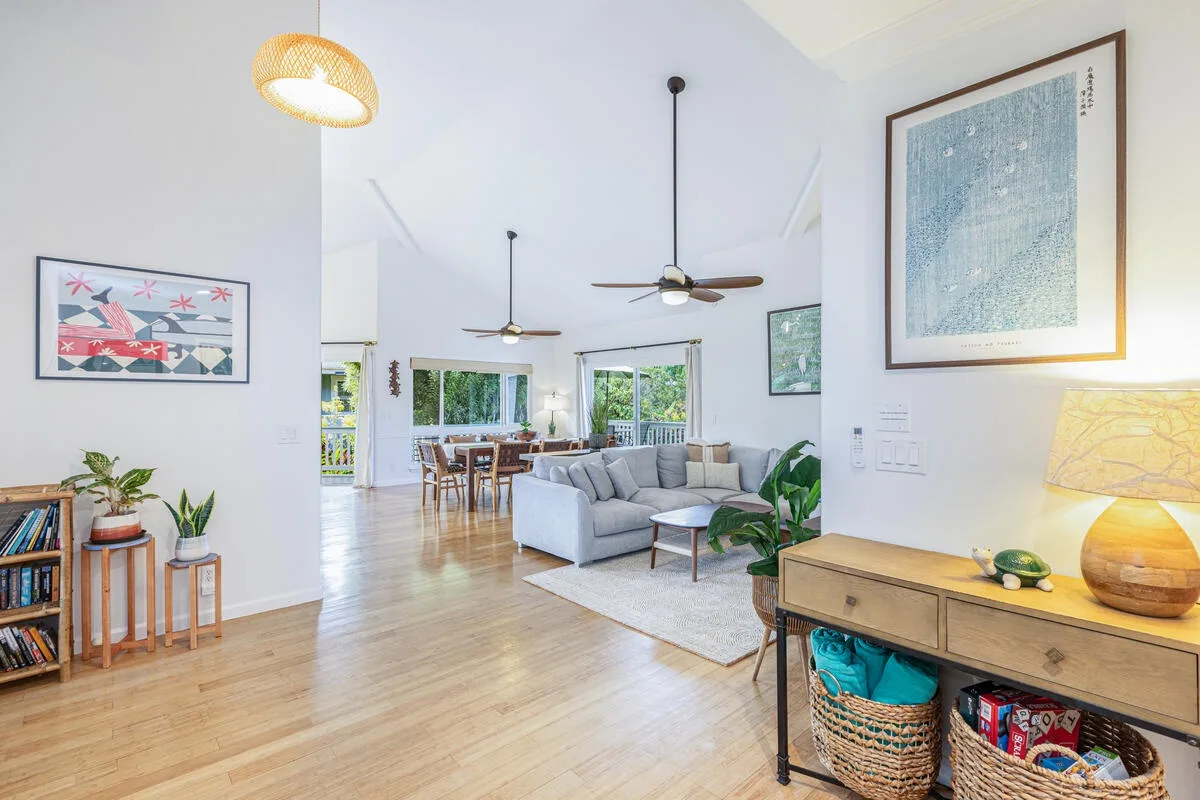 Una sala luminosa con zona de estar gris, mesa de centro y consola de madera.