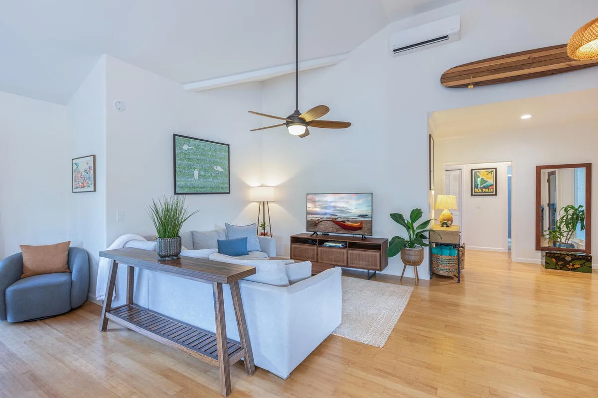 Una sala luminosa con asientos, una mesa de centro y un televisor.