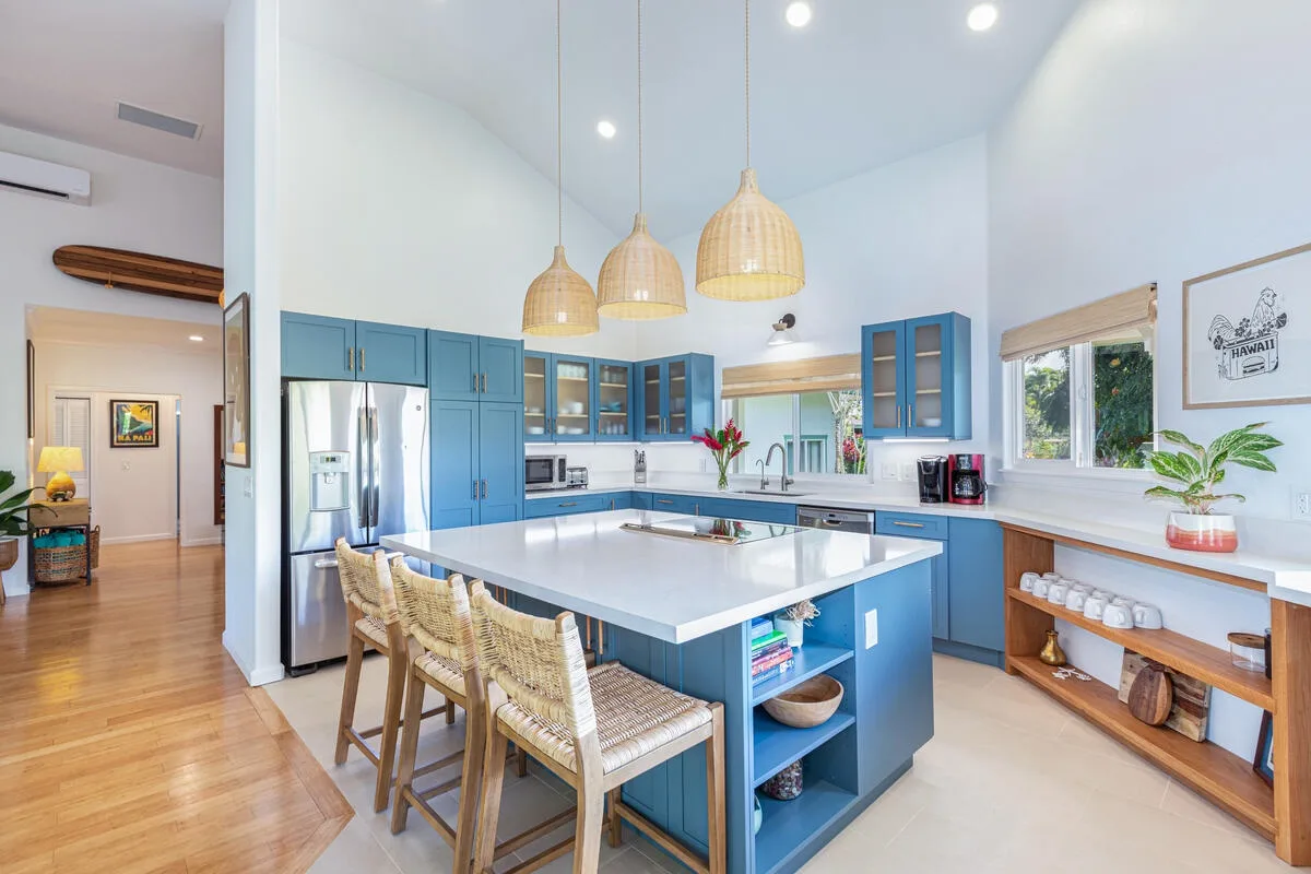 Una cocina luminosa con gabinetes azules y una gran isla central.