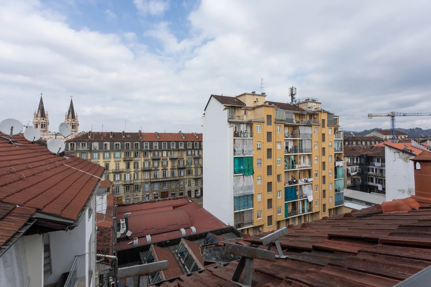 Azoteas urbanas y edificios de apartamentos bajo un cielo parcialmente nublado.