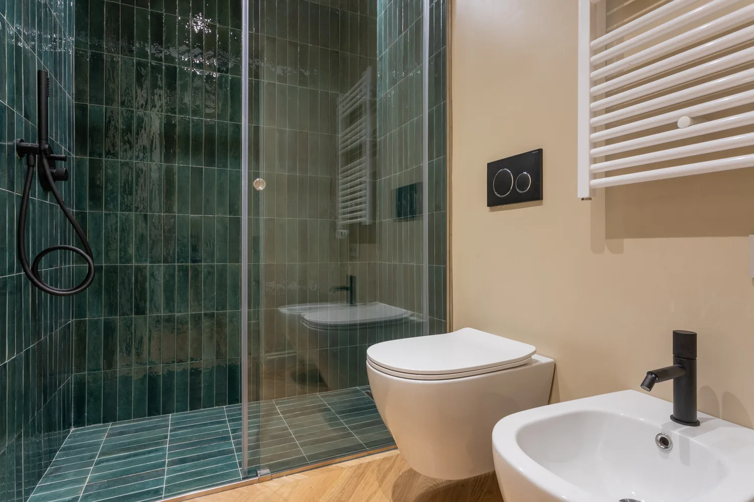A bathroom with a glass shower, toilet, and sink.