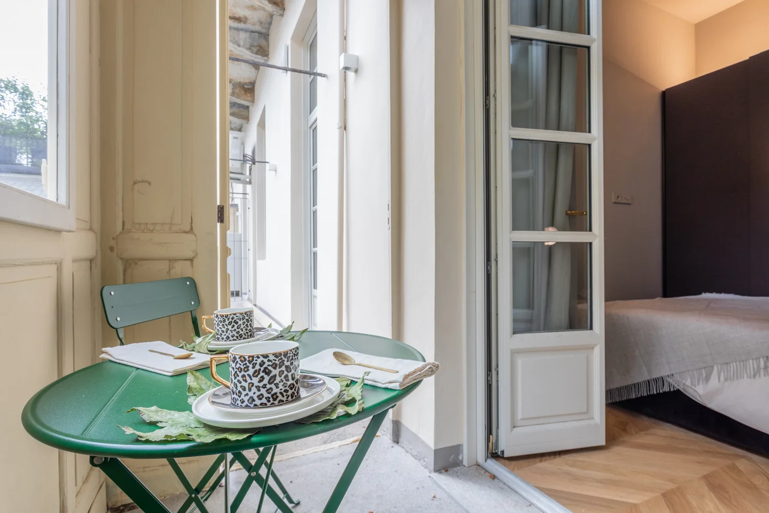 A small dining table sits beside an open doorway to a bedroom.