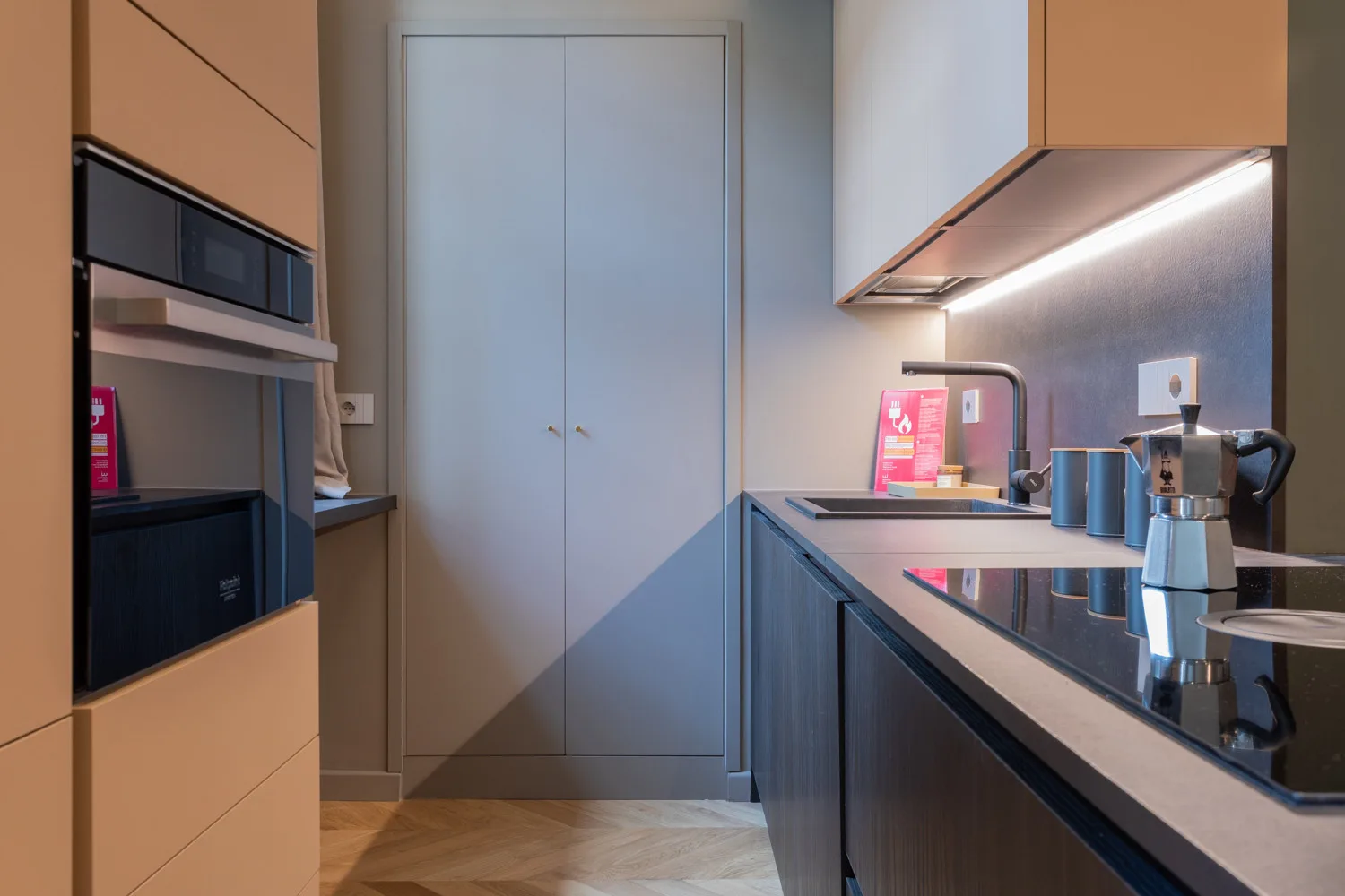 A modern kitchen with built-in appliances and a counter with small appliances.
