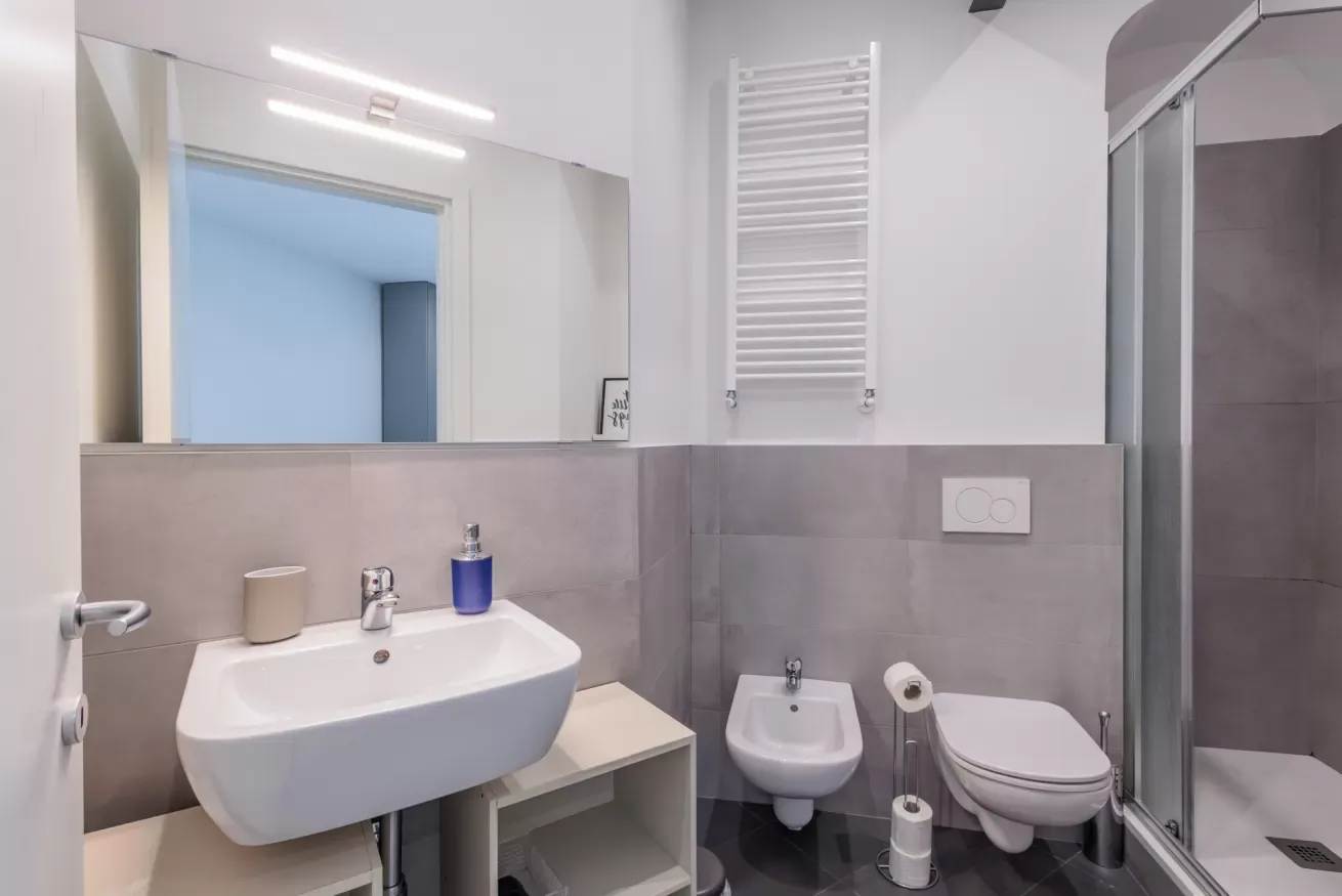 Un baño moderno con lavabo suspendido y ducha.