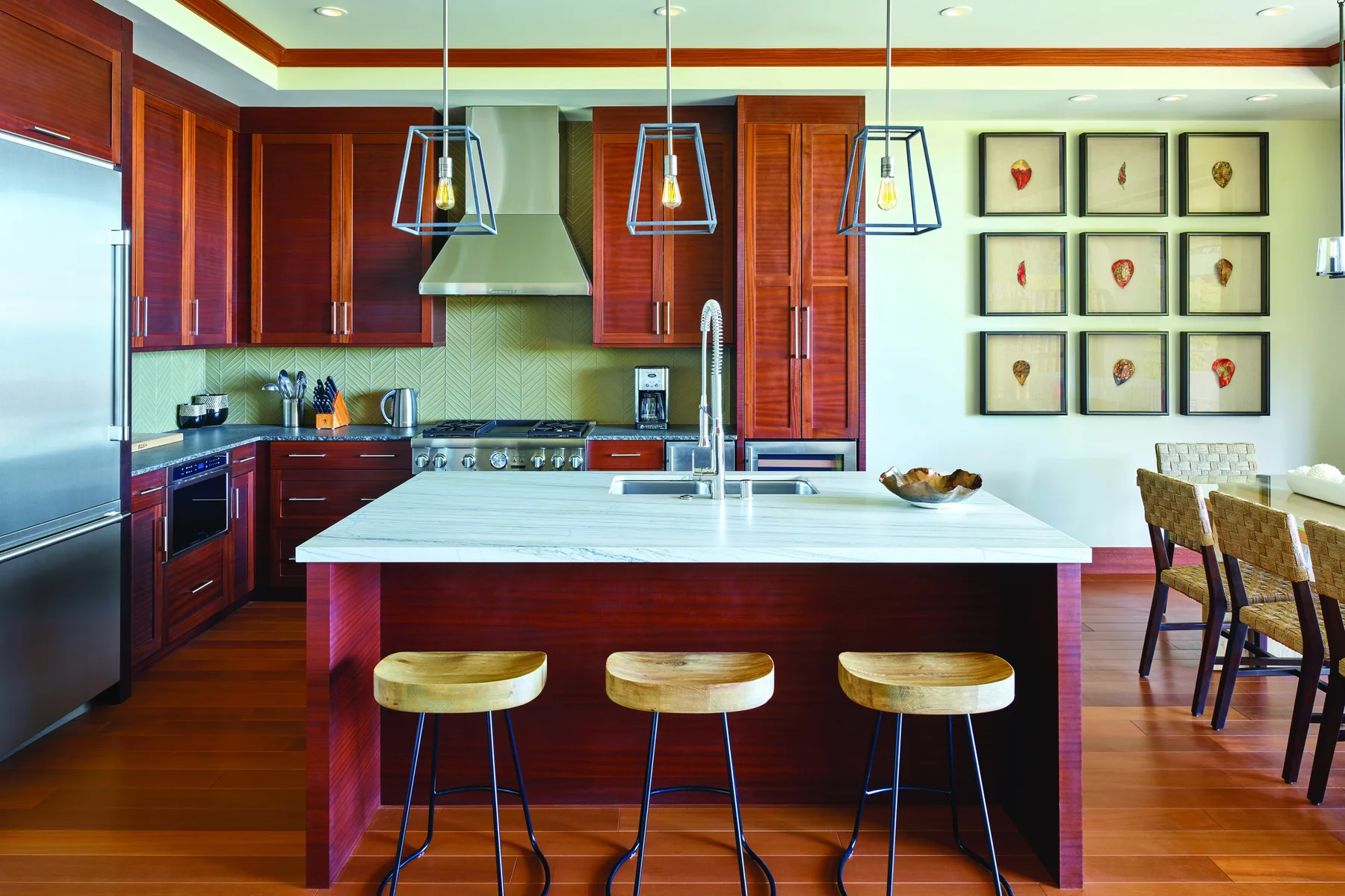 Una cocina moderna con una isla grande y luces colgantes.