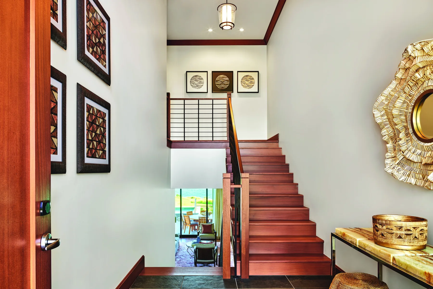 Una escalera interior con peldaños de madera y cuadros en las paredes.