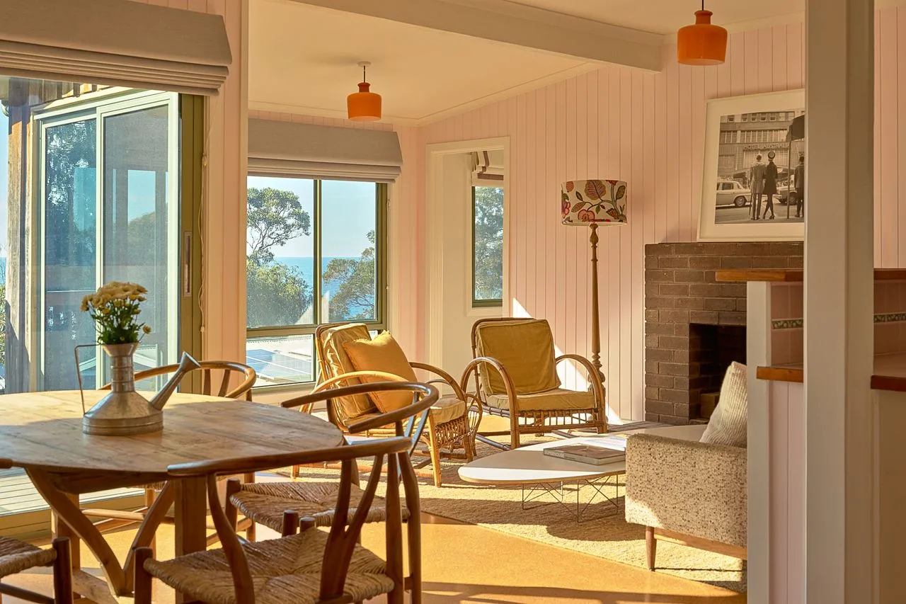 A bright living and dining area with seating beside large windows.
