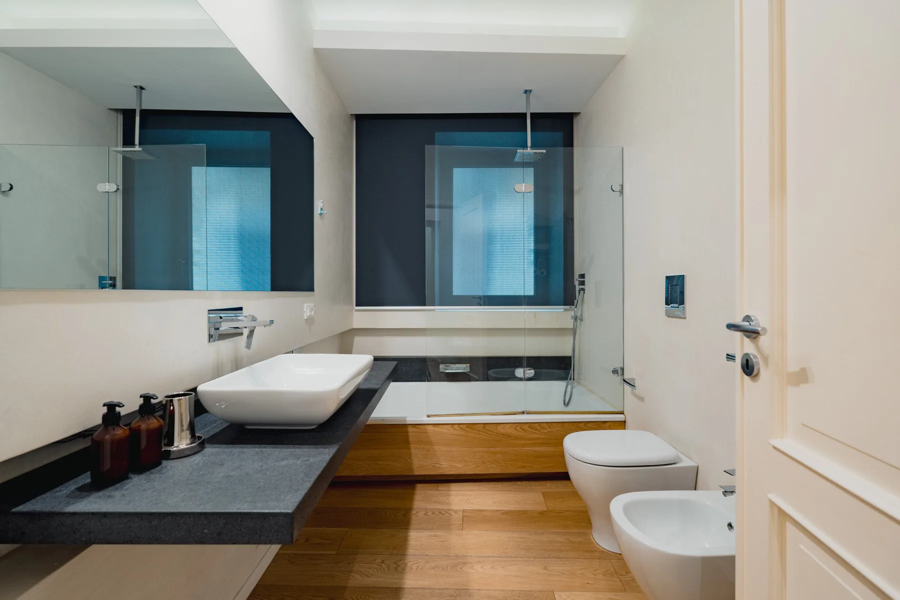 Un baño con un lavabo amplio, una bañera y una ducha de vidrio.