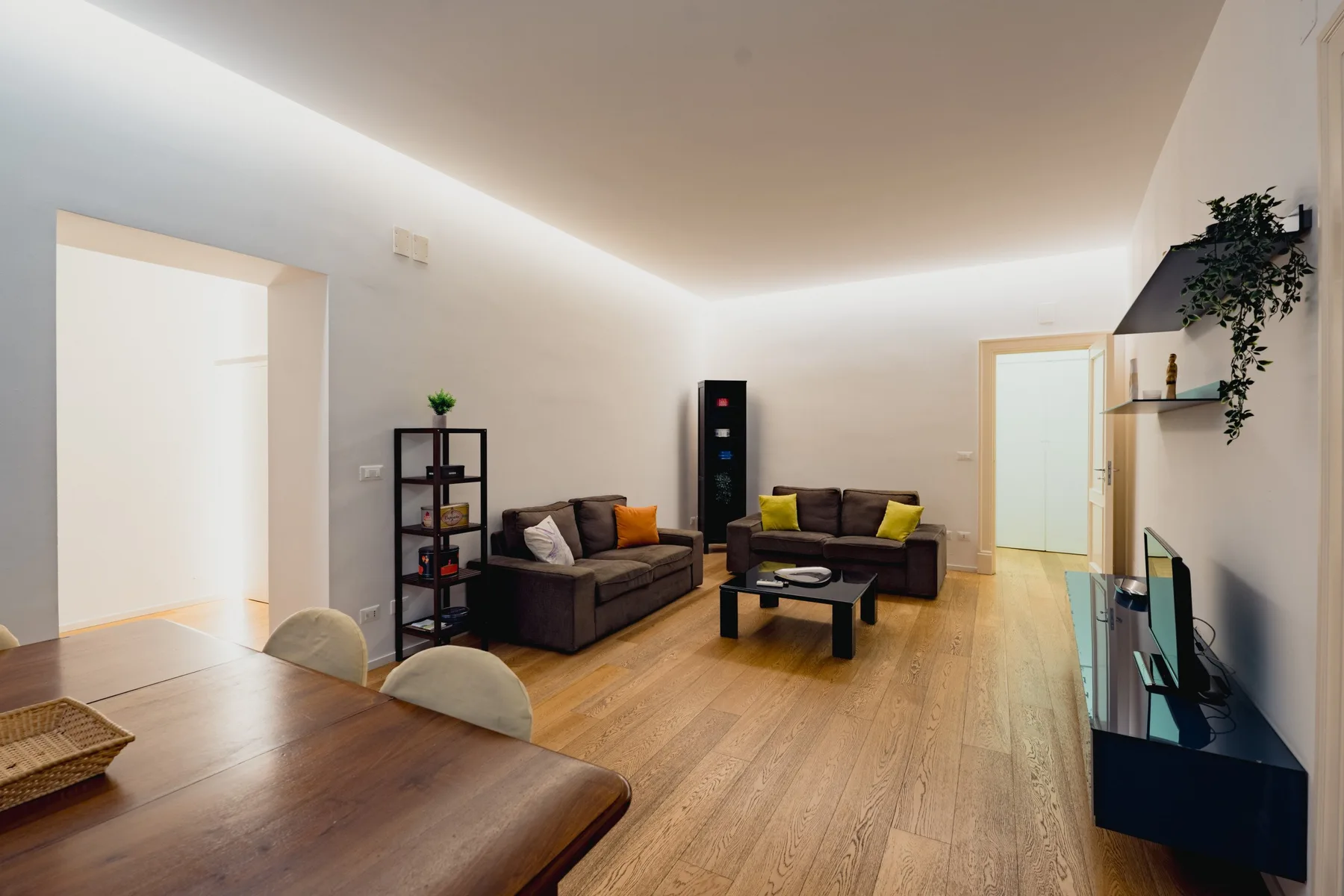 Una sala de estar con asientos alrededor de una mesa de centro y un televisor.