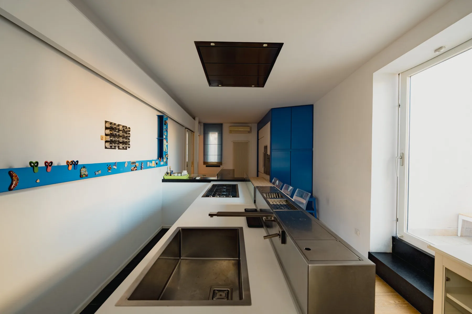 Una cocina moderna con una encimera larga y armarios azules.