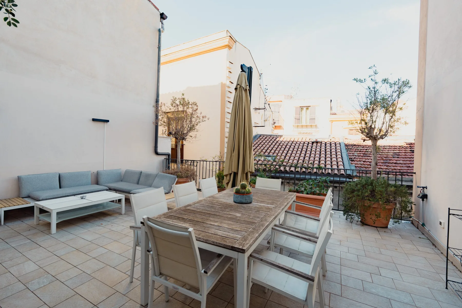 Una terraza en la azotea con asientos al aire libre y una mesa de comedor.