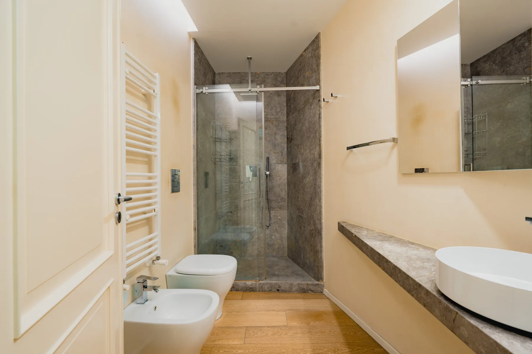 Un baño con ducha de cristal, lavabo e inodoro.