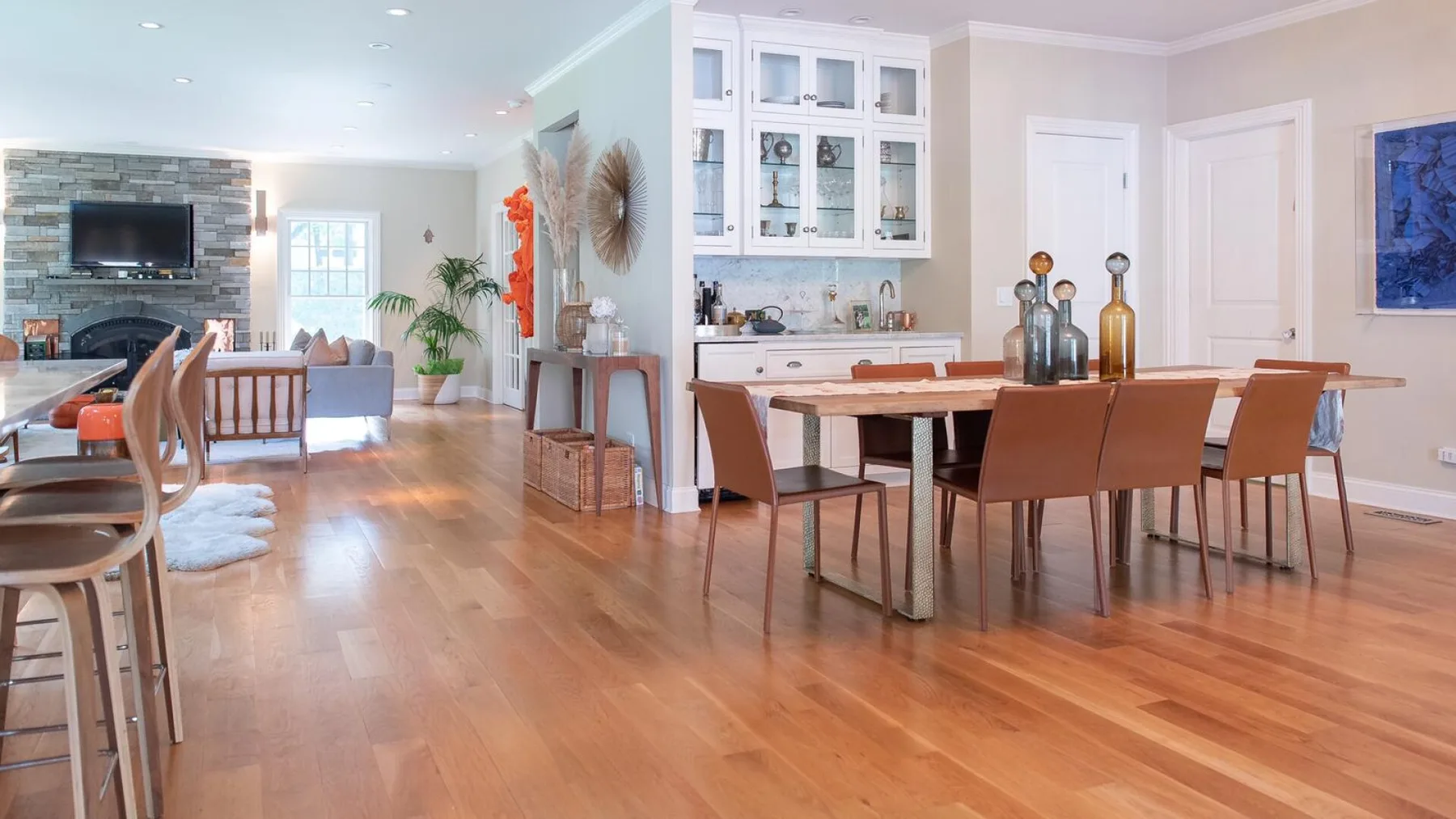 Una sala de estar y comedor de planta abierta con una mesa de madera y asientos.