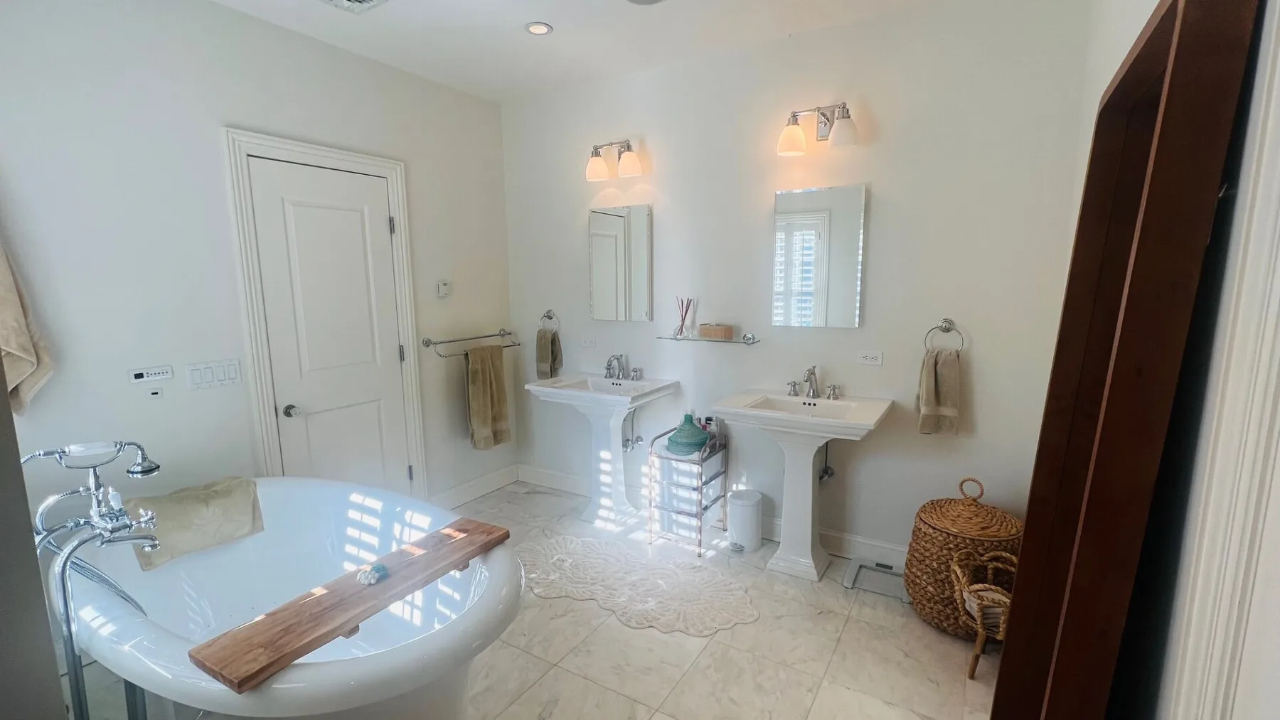 Un baño luminoso con bañera y un lavabo doble.