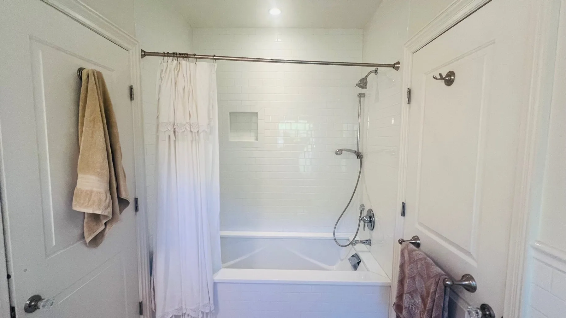 Un baño con bañera, ducha y cortina de color claro.