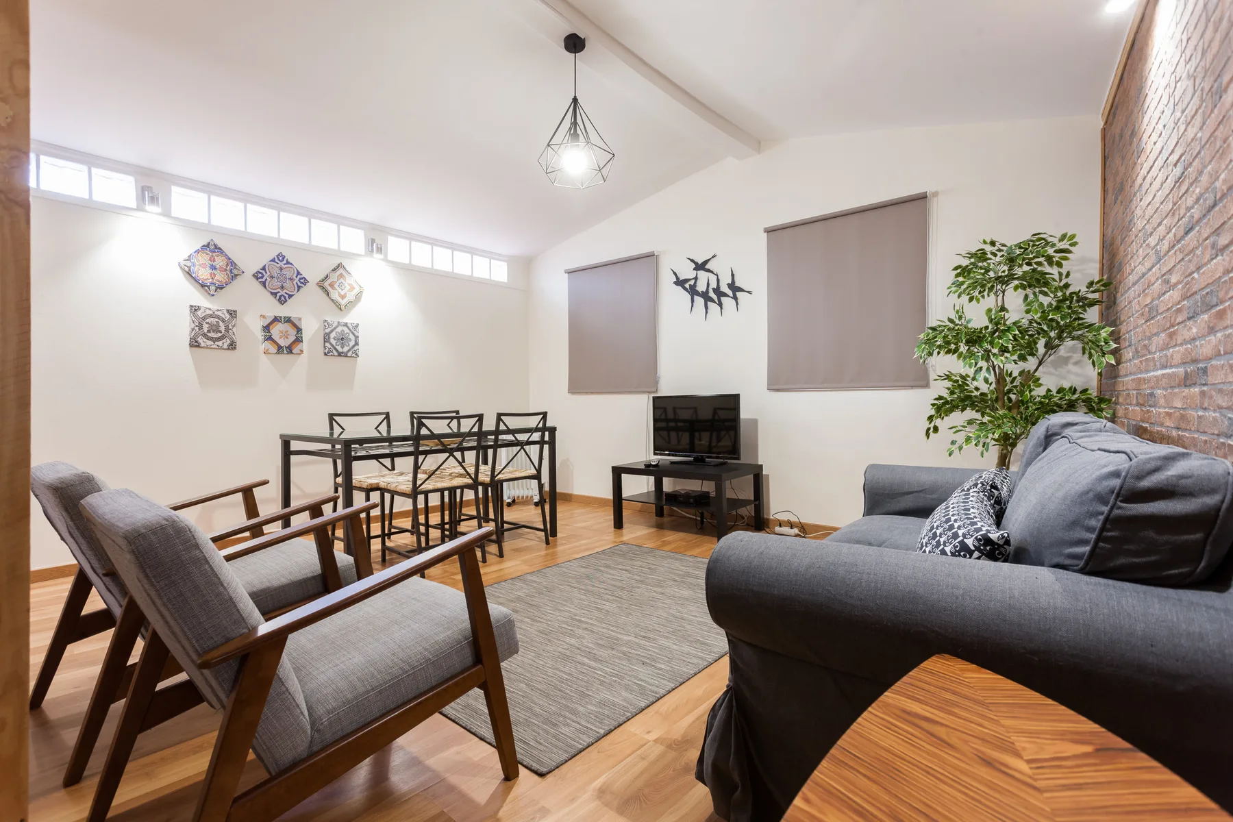 Una sala de estar con asientos, una mesa de comedor y un televisor.