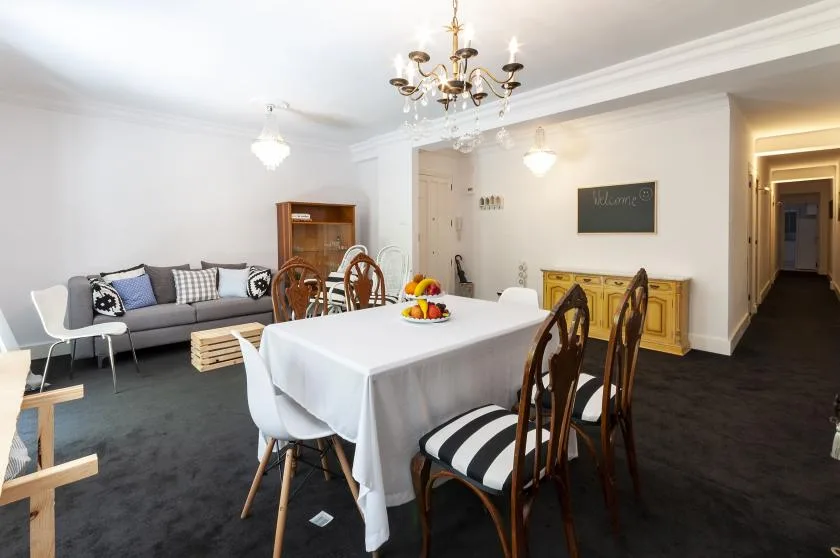 A dining and living area with a table, chairs, and seating.
