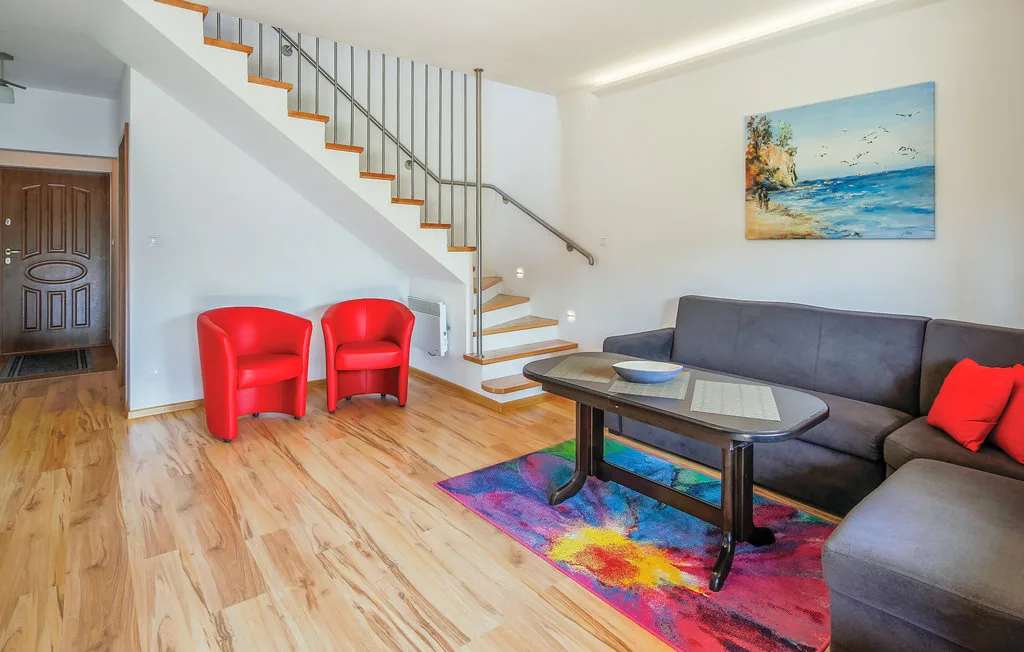 A living room with a sectional sofa, coffee table, and staircase.