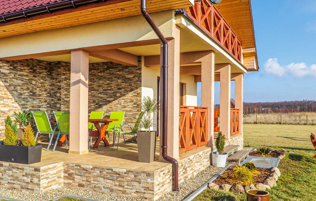 A covered outdoor patio beside a house, with a dining table and seating.