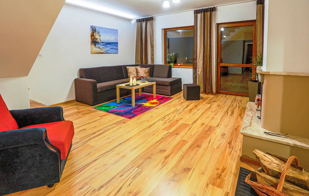 Una sala de estar con asientos alrededor de una mesa de centro y una alfombra colorida.