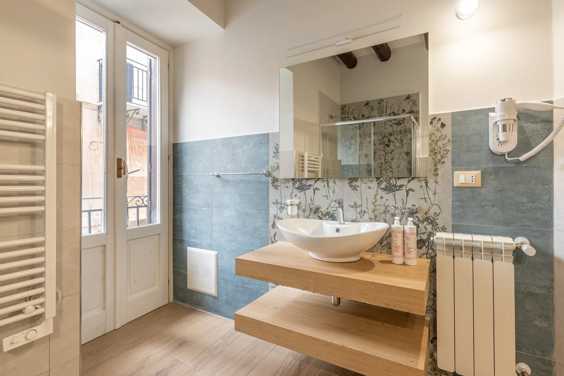 A bathroom with a vessel sink and glass shower area.