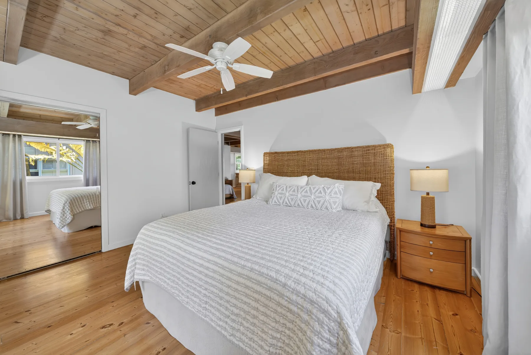Un dormitorio con una cama bajo un techo abovedado de madera con vigas expuestas.