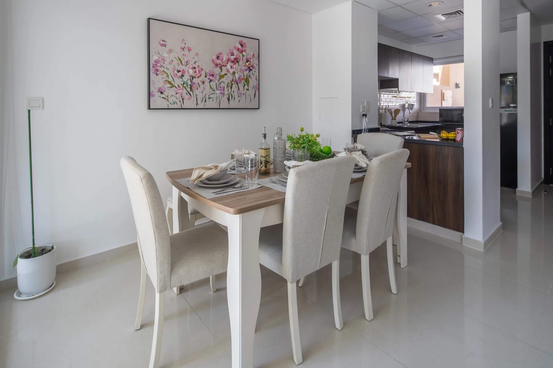 Un comedor con la mesa puesta junto a una cocina abierta.