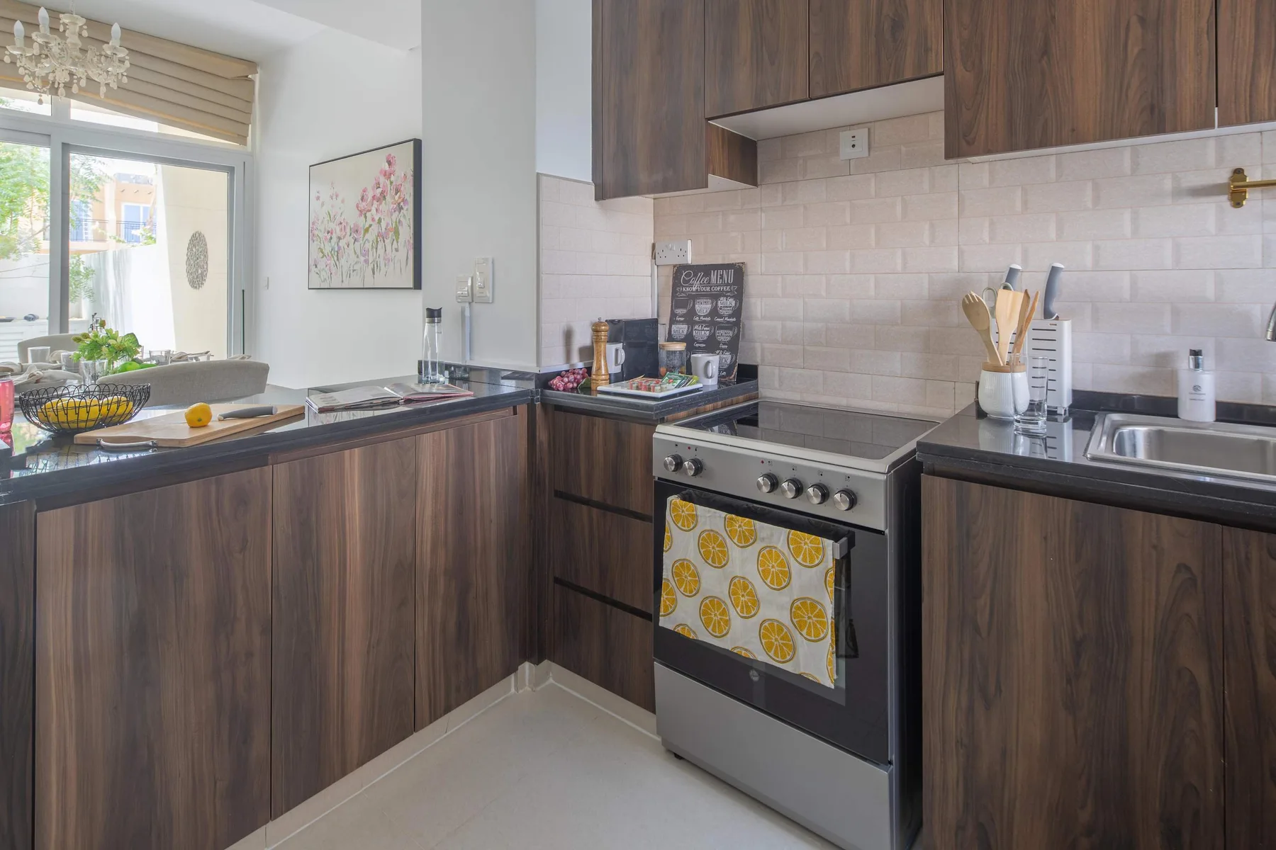 Una cocina con gabinetes de madera oscura, una estufa y un fregadero.