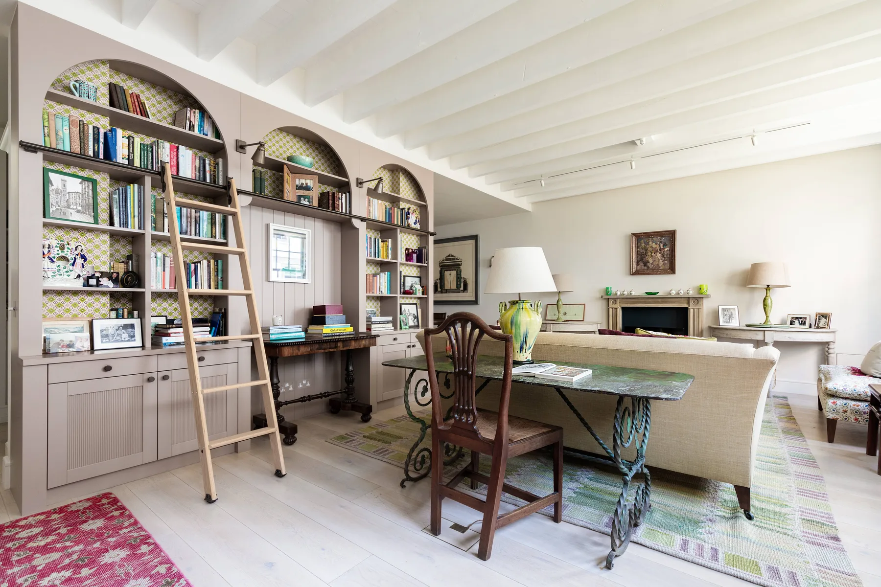 A bright living room with built-in bookshelves, a desk, and seating.