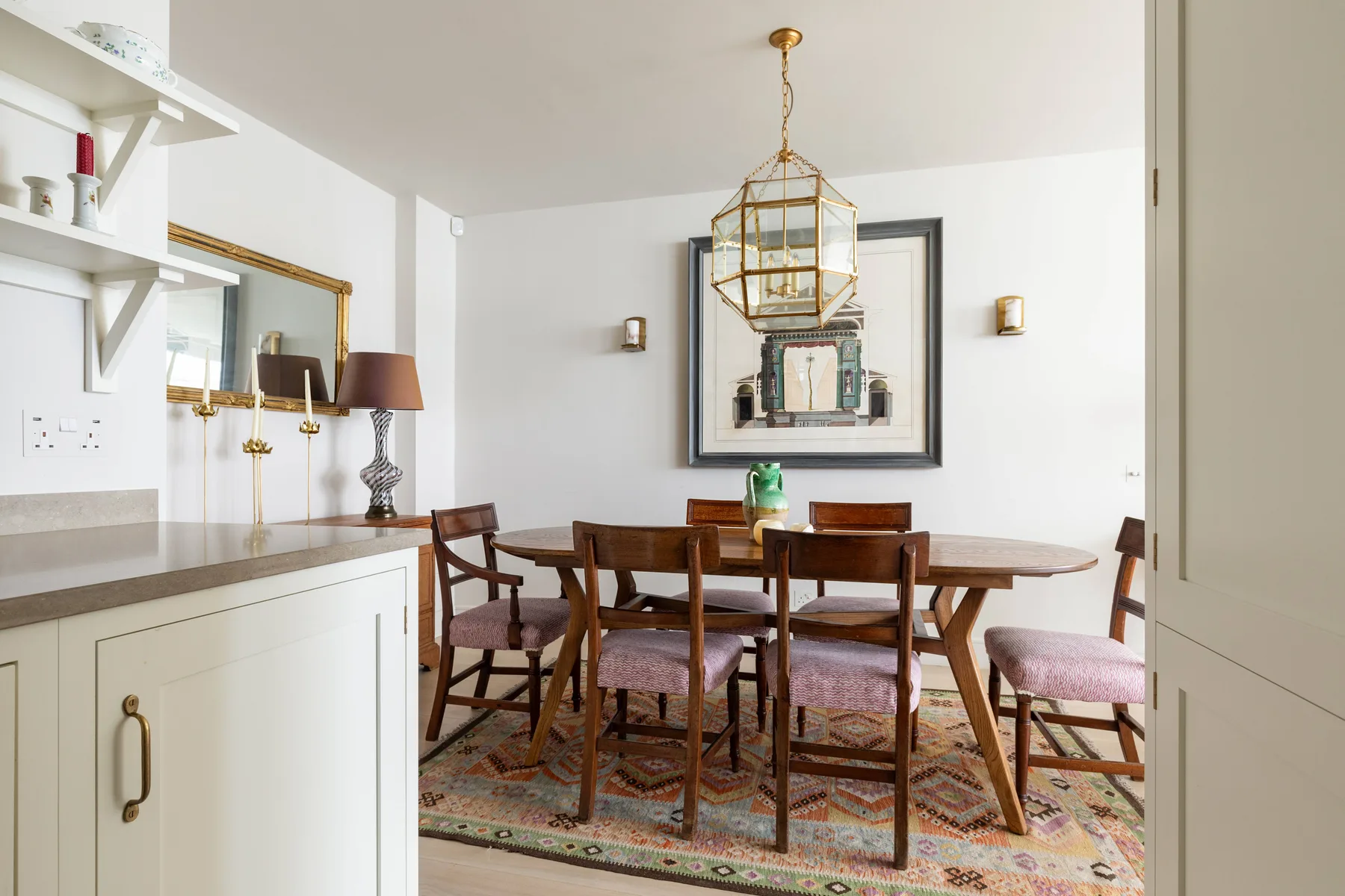A dining area with a wooden table and chairs beneath a hanging light.
