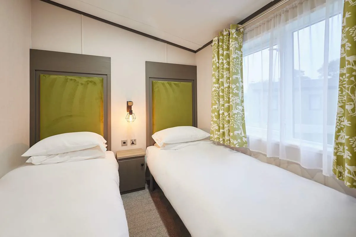 Un dormitorio con dos camas y una gran ventana con cortinas.