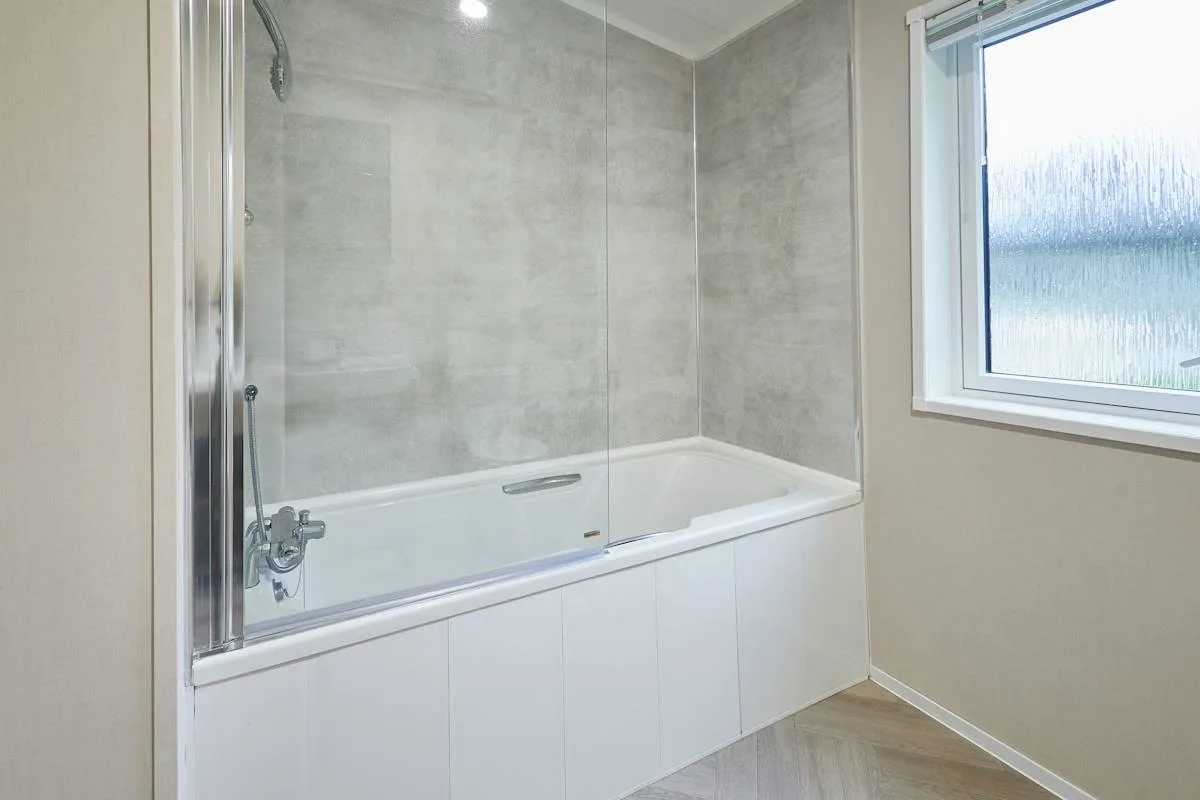 Un baño con bañera y ducha junto a una ventana.