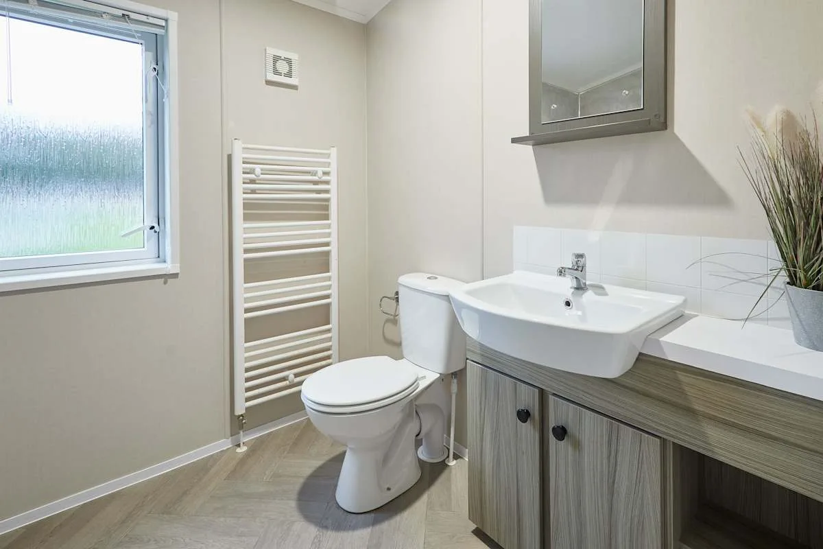 Un baño con lavabo, inodoro y ventana.