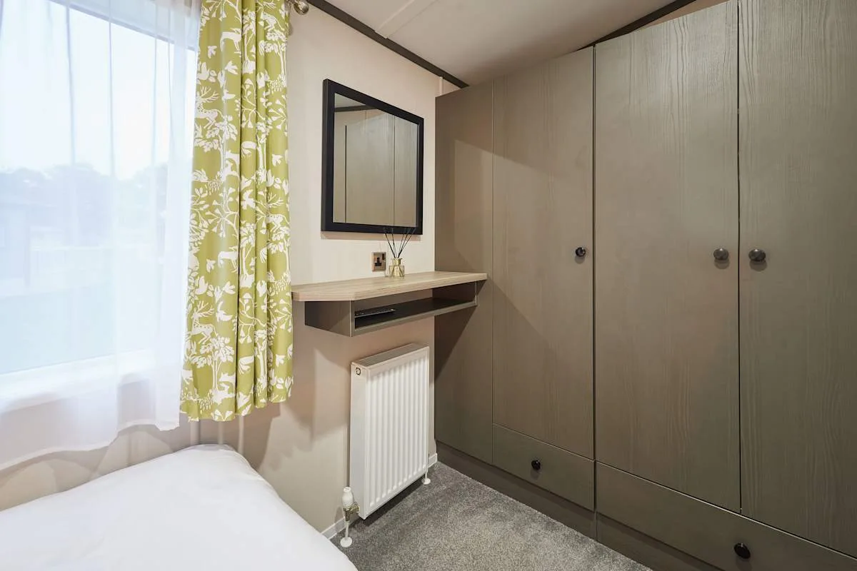 Dormitorio con una ventana, tocador y armario grande.