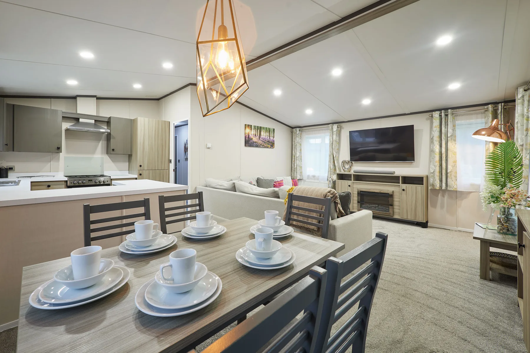 An open-plan living and dining area with a set dining table and television.