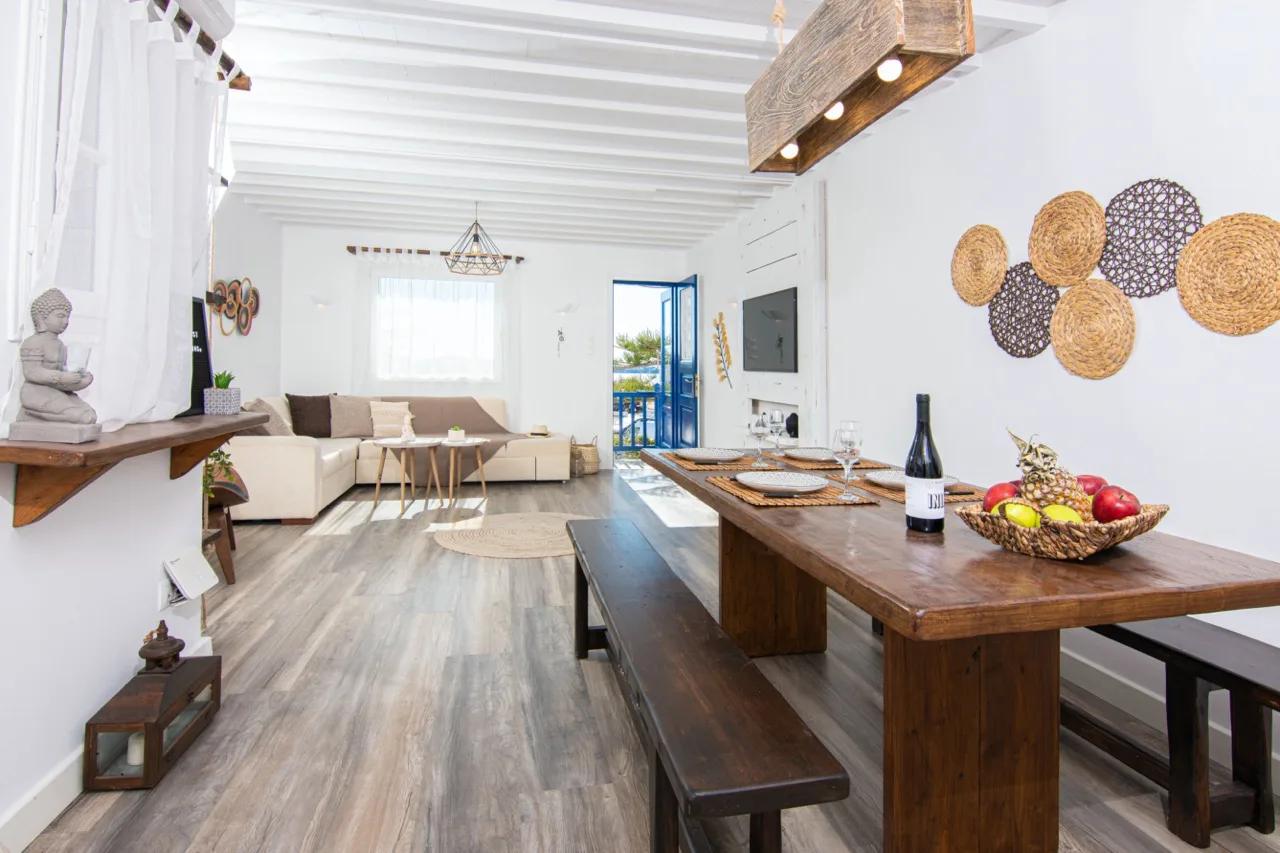 Una luminosa sala de estar y comedor diáfana con una larga mesa de madera.