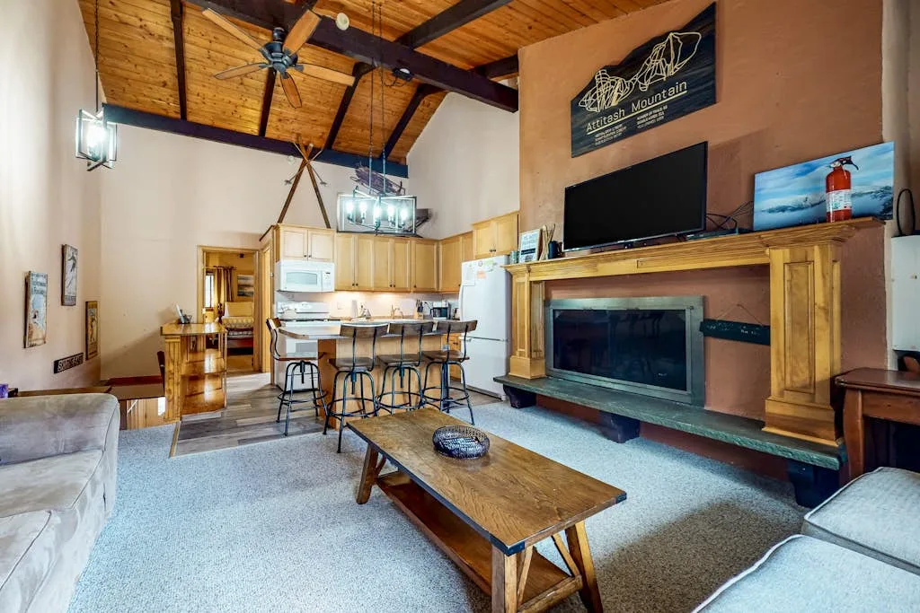 Una sala de estar con chimenea, televisor y mesa de centro de madera.