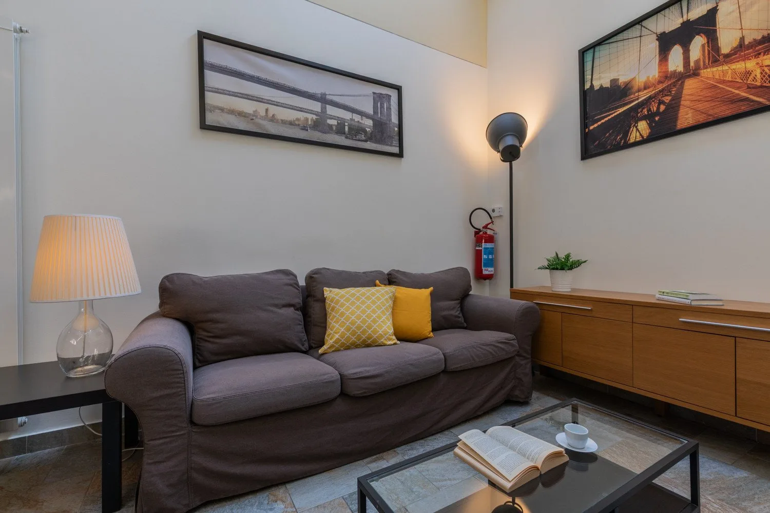 A living room with a sofa, framed wall art, and a low coffee table.
