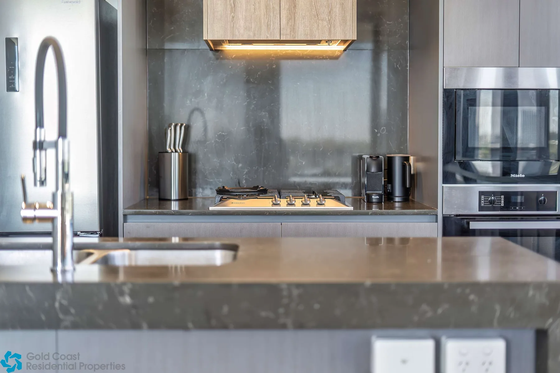 Una cocina moderna con una placa de cocción, encimera y electrodomésticos integrados.