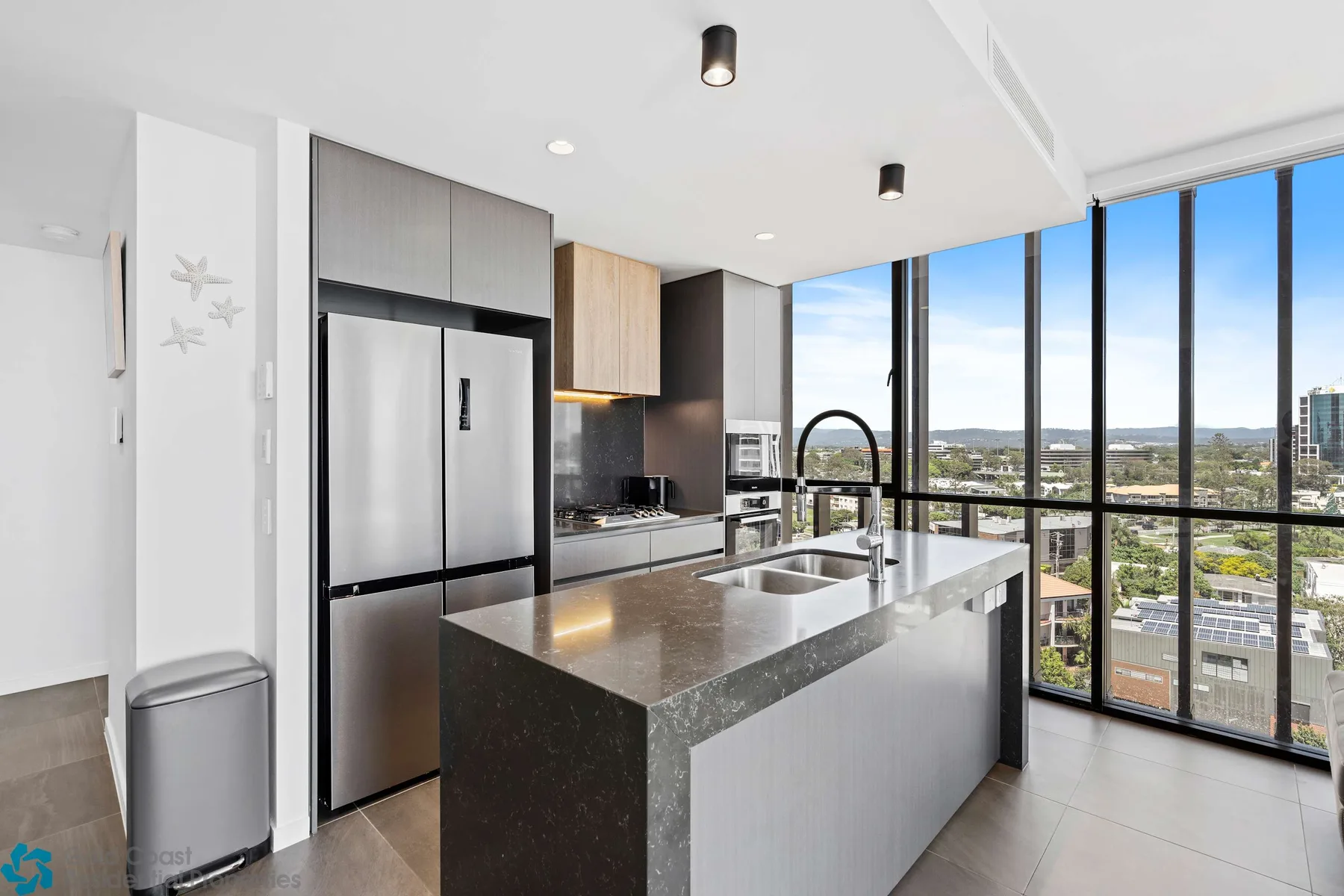 Una cocina moderna con una isla amplia y ventanas con vistas a la ciudad.