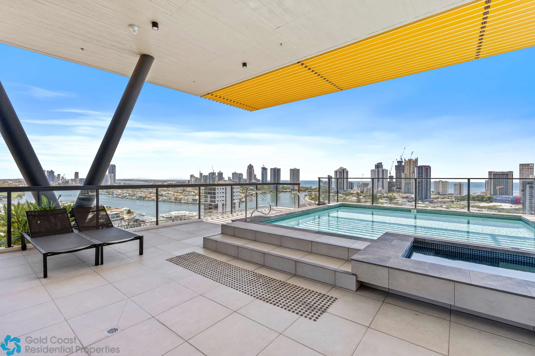 Una terraza con piscina en la azotea ofrece vistas del perfil urbano bajo una cubierta.