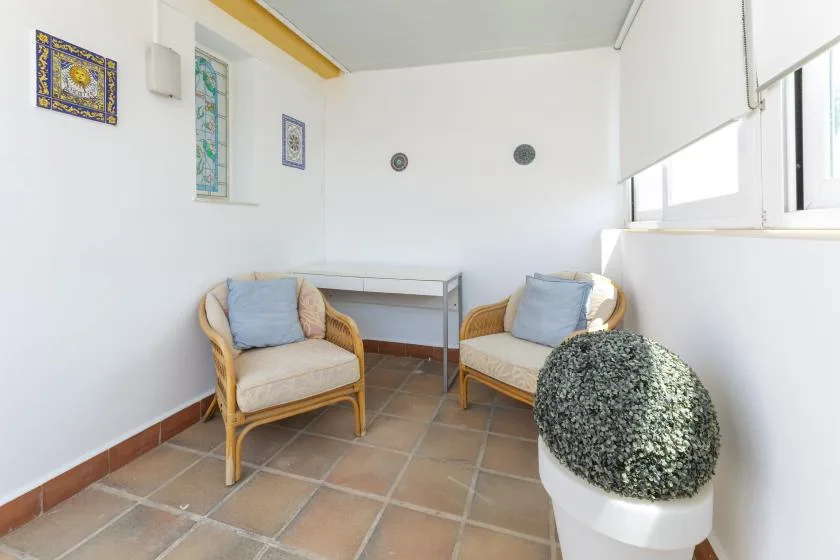 A bright sitting area with two cushioned seats and a small table.