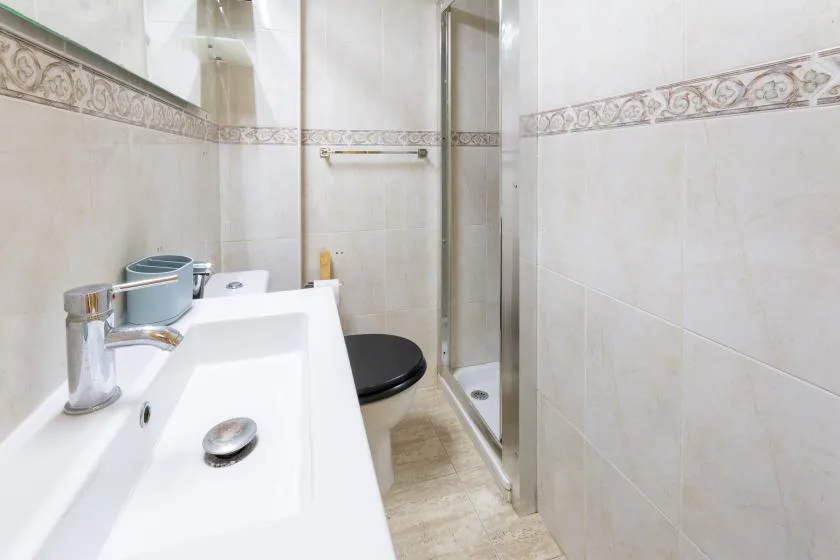 A tiled bathroom with a sink, toilet, and shower.