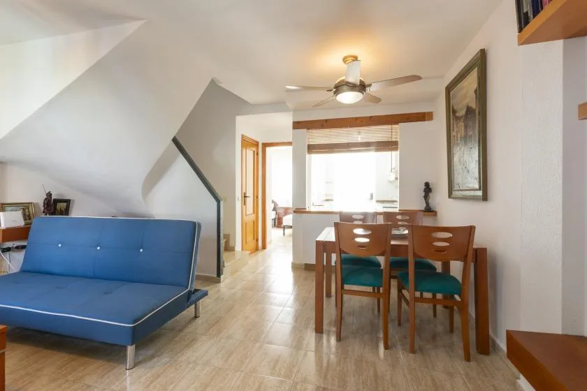 A dining area with wooden seating and a blue upholstered bench.