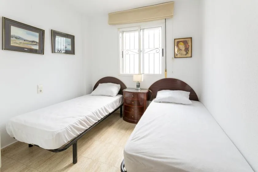 A bedroom with two single beds and a small bedside table.