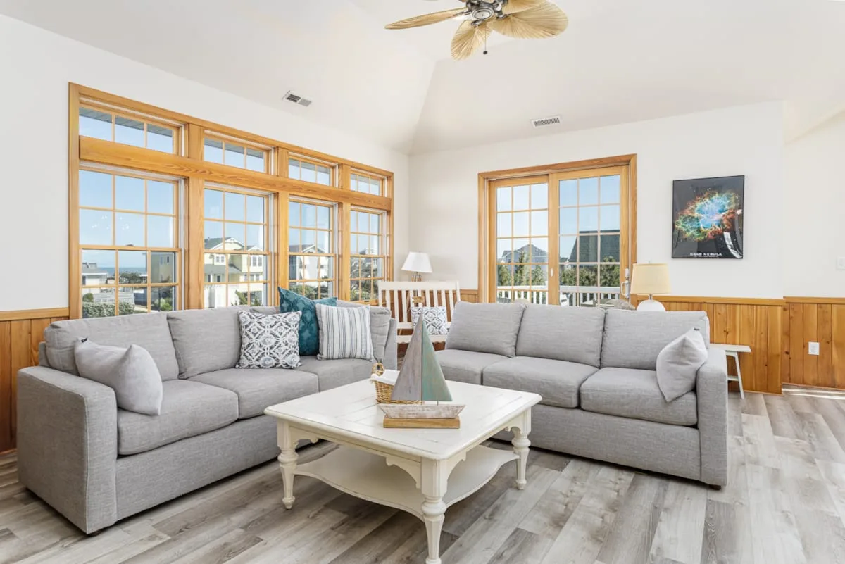 A living room with gray seating arranged around a white coffee table.