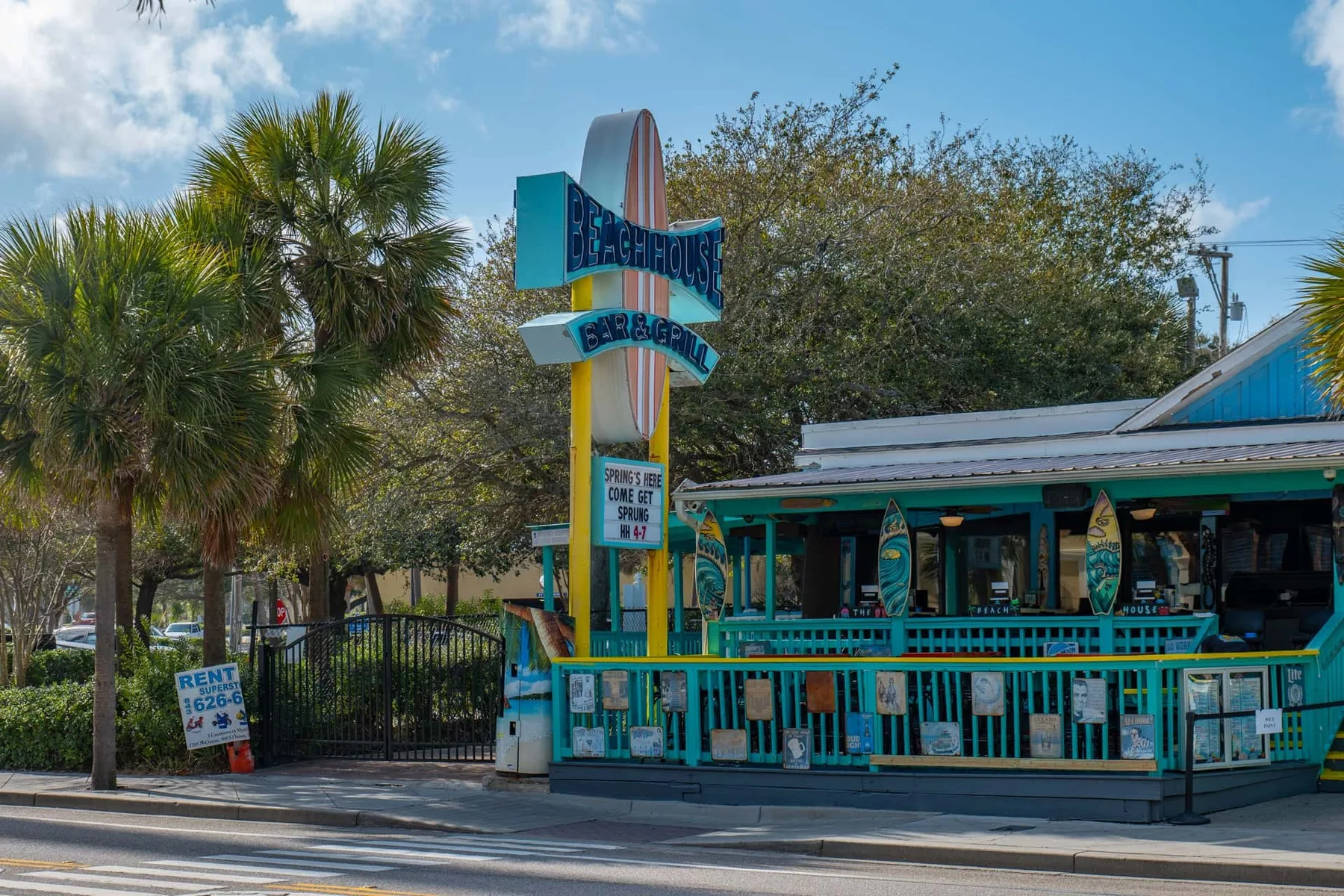A colorful roadside restaurant with a tall sign and outdoor seating.