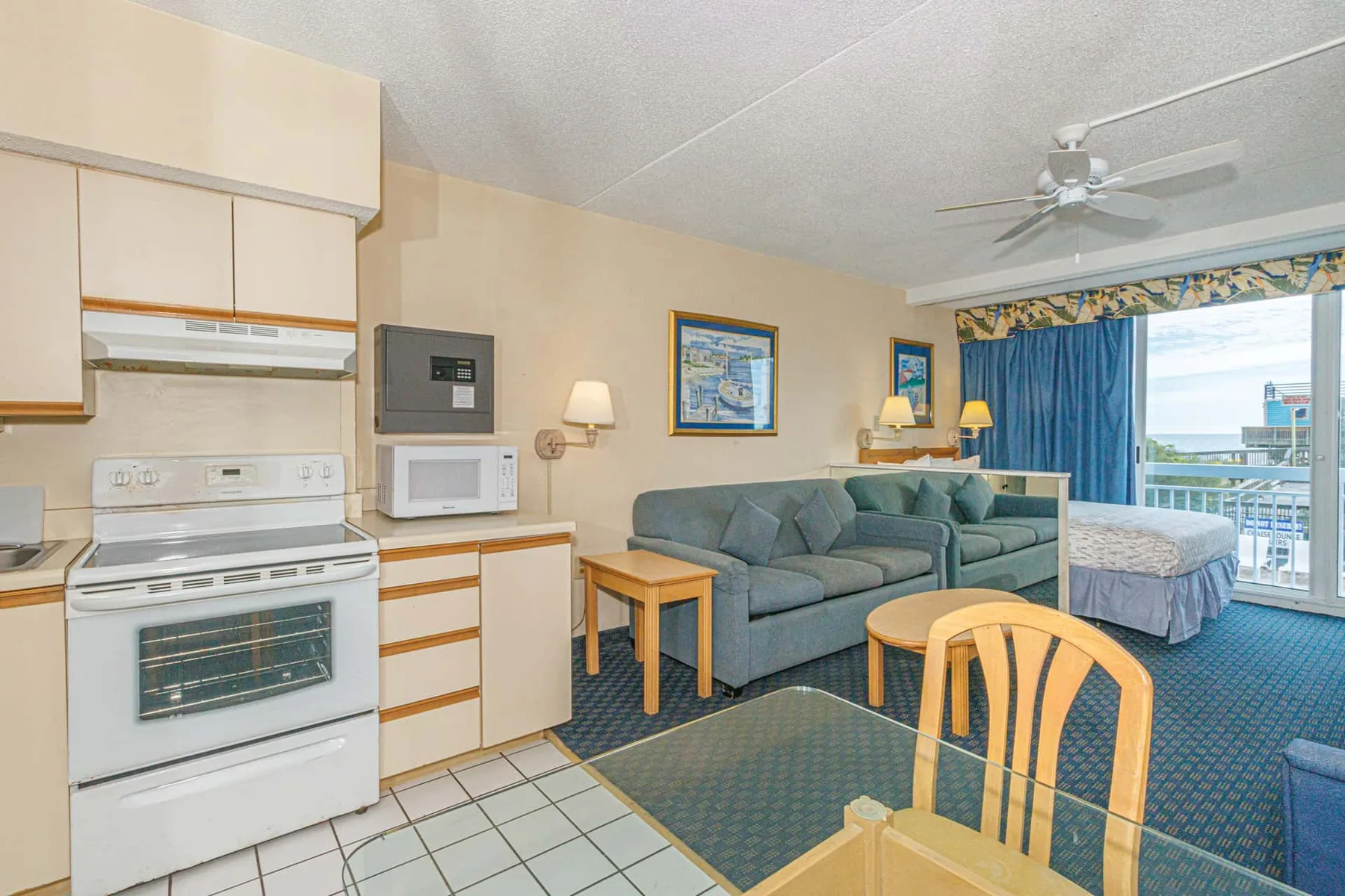 A combined kitchen and living area opens onto a sleeping area by the balcony.