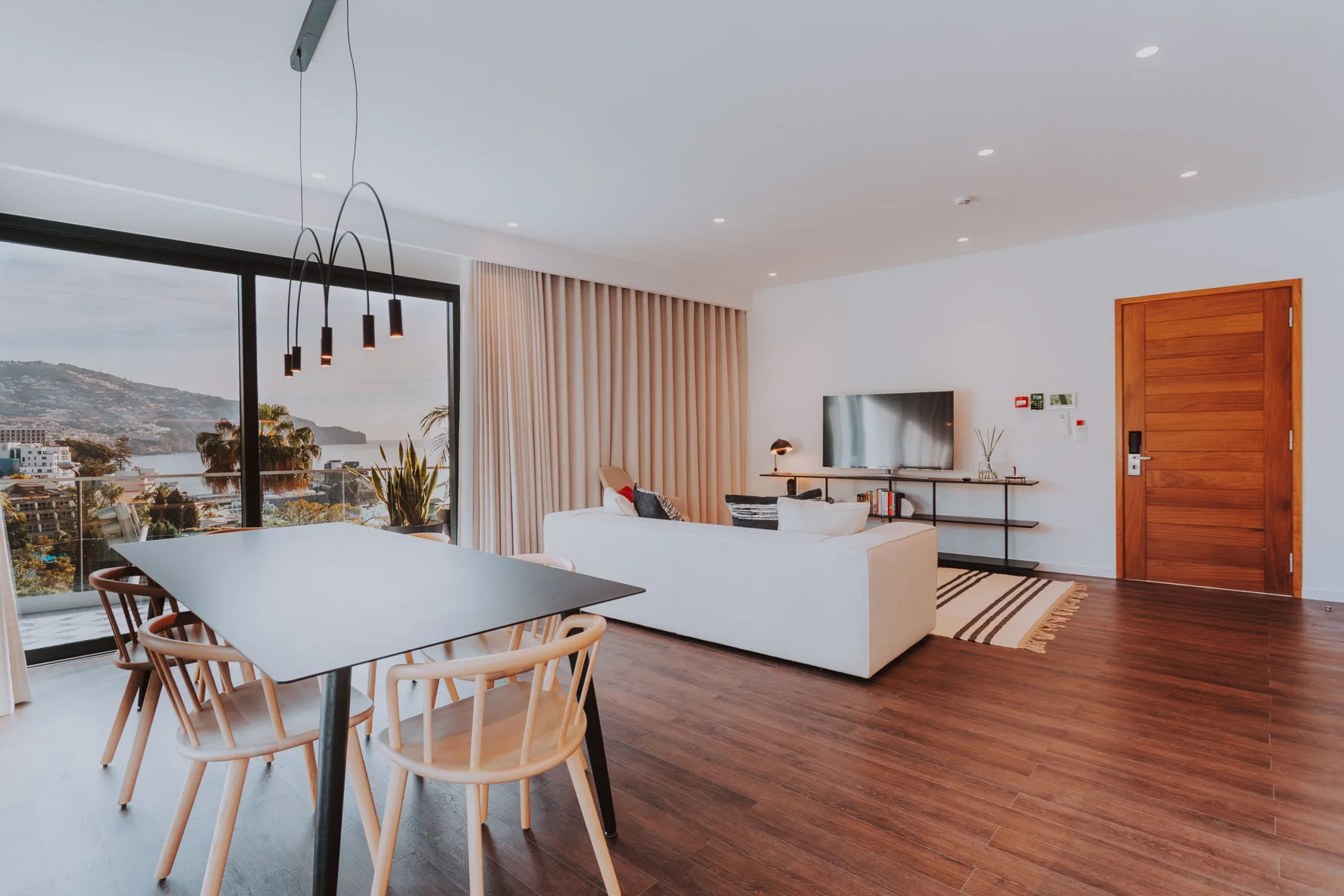Sala de estar y comedor de concepto abierto con mesa, asientos y televisor.